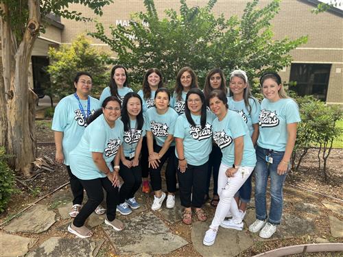 The Skaggs Structured Units Team smiling in their pastel blue team shirts.